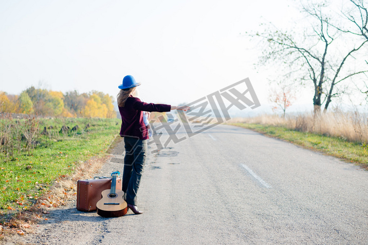 Young lonely woman and baby hitchhiking