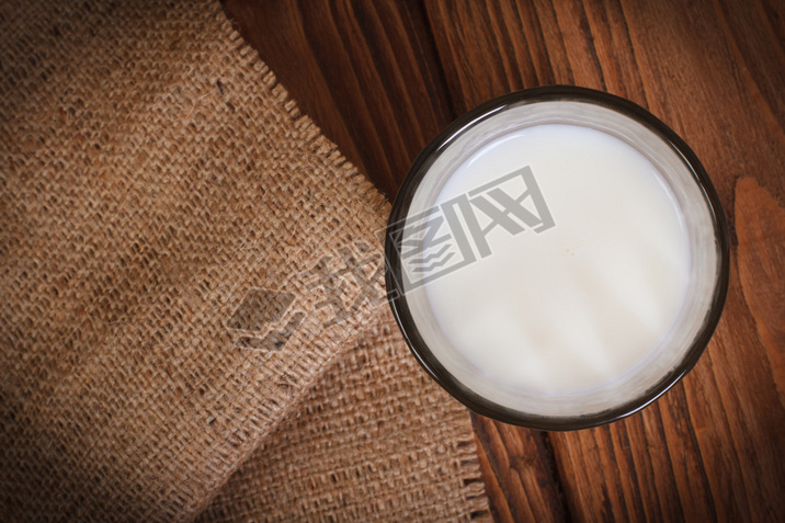 Milk in a glass on a wooden table top view