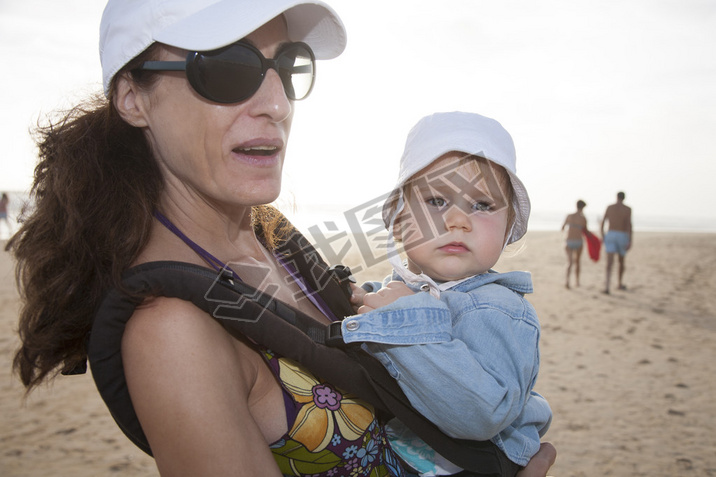 mom and baby in rucksack at beach