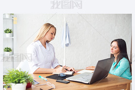 Doctor talking to patient in office, taking notes.