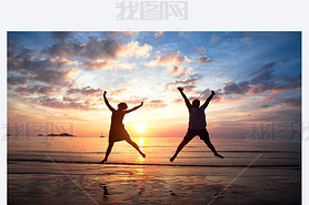 Concept of long-awaited vacation: Young couple in a jump on the sea beach at sunset.