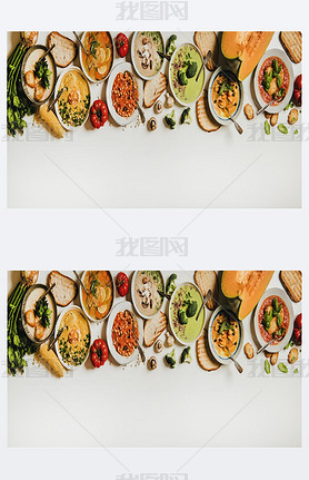 Flat-lay of creamy homemade soup in plates with bread slices over white plain table background, top 