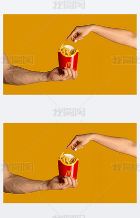 KHAV, UKRAINE - APRIL 4, 2020: Men and woman with package of french fries from McDonalds on orang