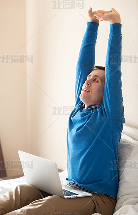 Young man stretching after working on computer