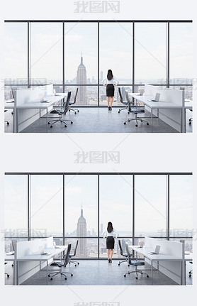 Rear view of a brunette who is looking out the window in the modern panoramic office with New York v