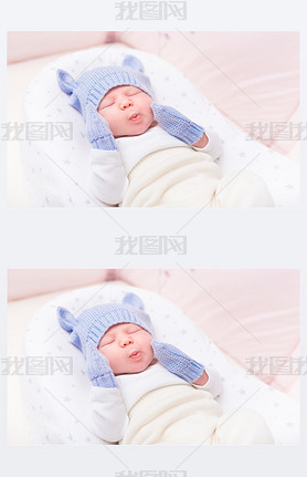 Cute little baby wearing knitted blue hat with ears and mittens lying in beautiful cradle with close