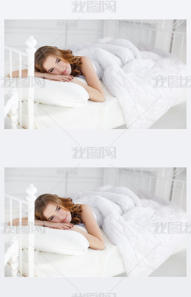 Beautiful girl wakes up in a white bed in the morning