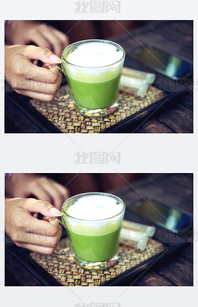 Woman holding Matcha green tea latte on wooden table