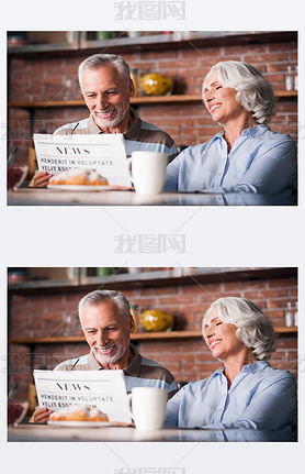 Grandparents reading newspaper together at kitchen table