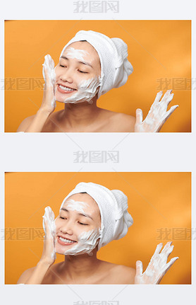 Close up beauty portrait of a laughing beautiful half naked Asian woman applying face cream and look