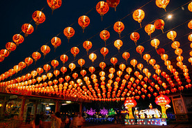 Red lanterns hanging in the black sky and god lamp at night in the Lantern Festival in Thailand.