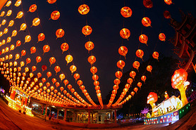 Red lanterns hanging in the black sky and god lamp at night in the Lantern Festival in Thailand.