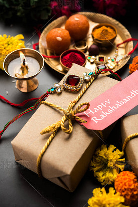 Raksha Bandhan / Rakshabandhan Rakhi with Haldi Kumkum rice, sweet Mithai, Gift Box, selective focus