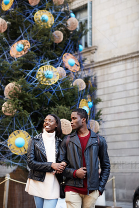 Laughing couple on christmas vacation walking in the city, beautiful young couple hing fun walking