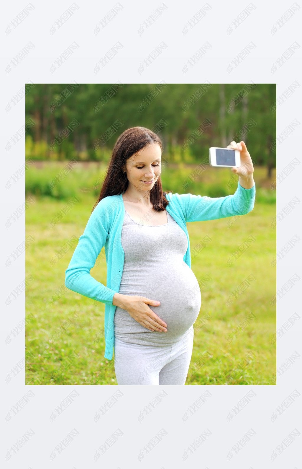 Happy young pregnant woman makes self-portrait on the artphone