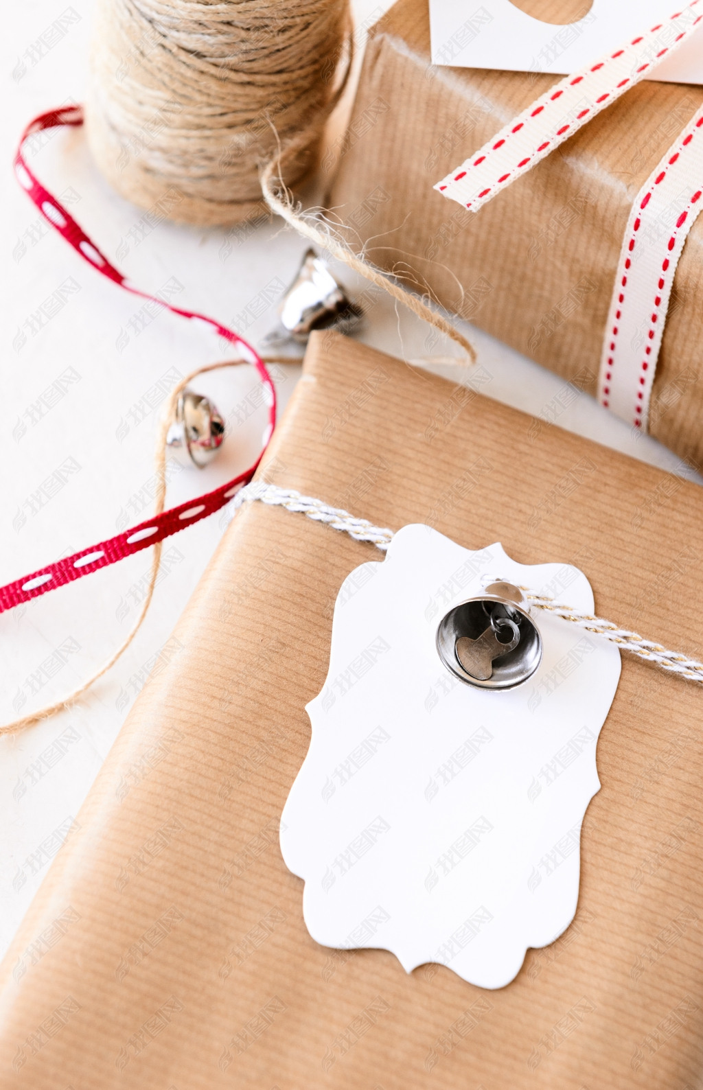 Wrapped gifts decorated with silver bells and gift tags 