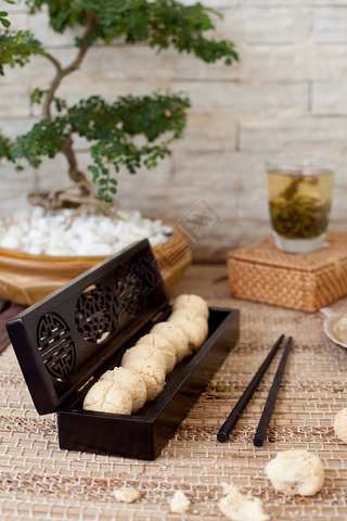 Traditional asian sesame cookies in a wooden box, green tea