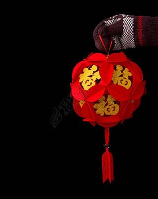 手拿着一个球形的灯笼为中国新年黑色与复制空间中文字意味着财富