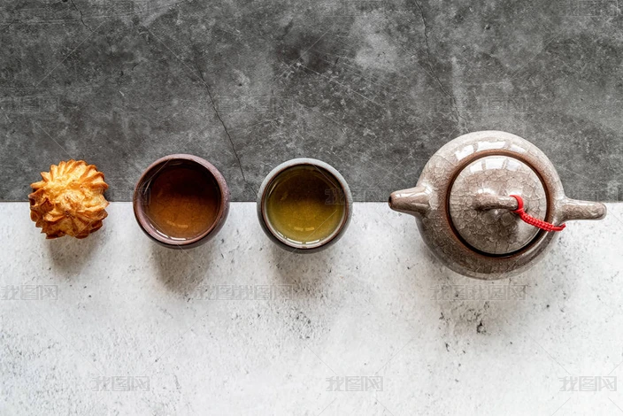 亚洲茶壶,杯子和蛋糕上的白色和黑色双背景顶视图平躺在