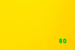 A green plastic toy number 80 is located in the lower right corner on a yellow background.