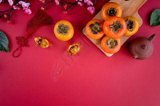 Top view of fresh sweet persimmons kaki with leaves on red table background for Chinese lunar new ye