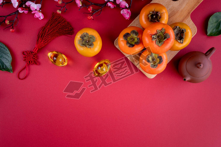 Top view of fresh sweet persimmons kaki with leaves on red table background for Chinese lunar new ye