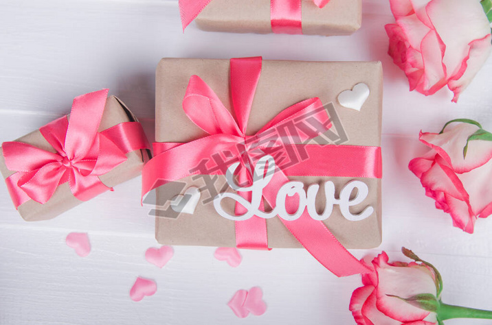 The word love in white letters on gift boxes with pink ribbons. Love concept, Valentine's day.