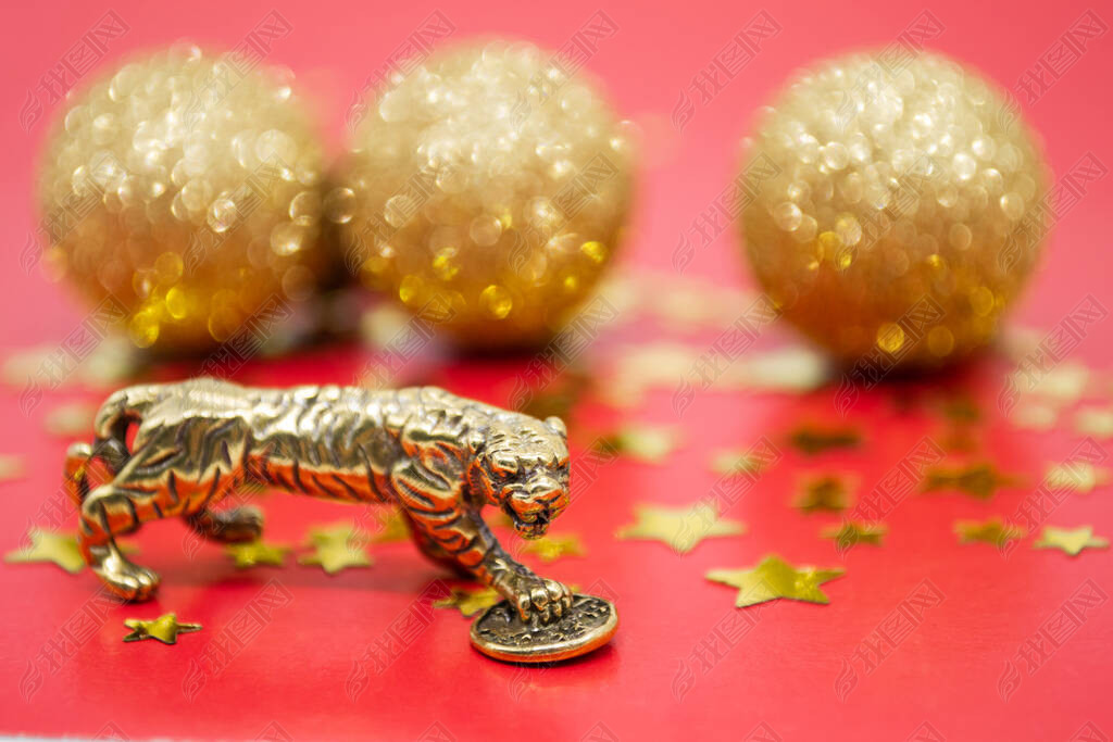 A bronze figure of a tiger with a coin - the symbol of the Chinese new year 2022 on a red background