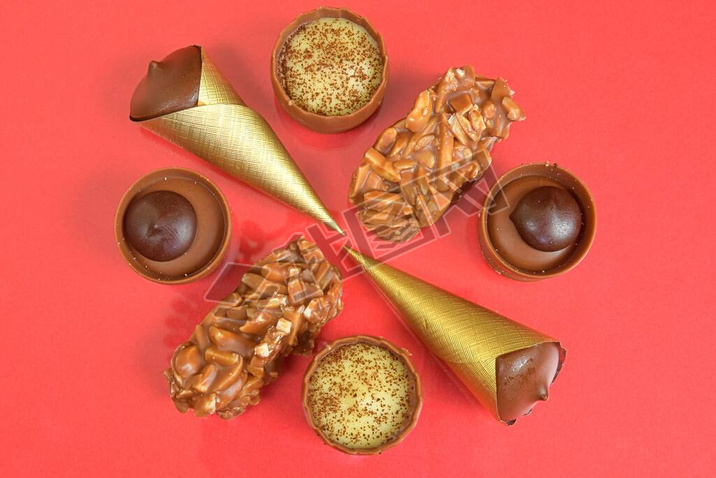 Top view of various chocolate pralines on pastel background. Top view of variety chocolate pralines.