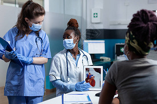 African american cardiologist doctor showing heart radiohraphy to sick patient