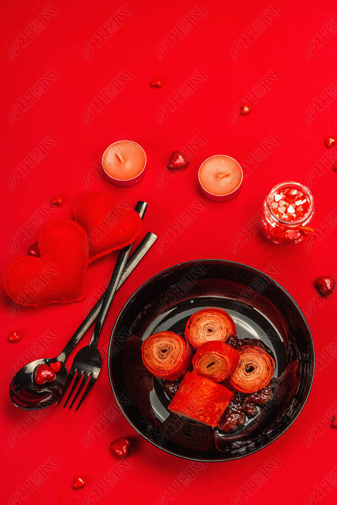 浪漫的早餐理念、红辣椒或薄薄的薄饼令甜甜的心充溢。情人节或母亲节的节日食品。草莓果酱、餐具、鲜红色背景、顶视图