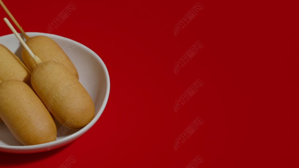 素材简介我图网提供近距离观察白色盘子,红色背景上有玉米热狗拍摄.