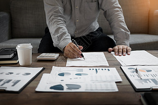 商人在办公室分析财务数据报告，研究利润图表和文档。