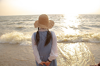 海边看日落的女生背影