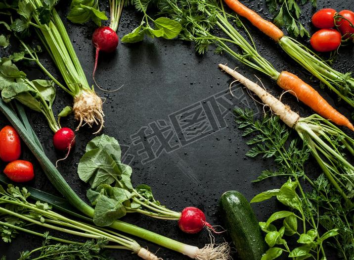 Young spring vegetables on black chalkboard