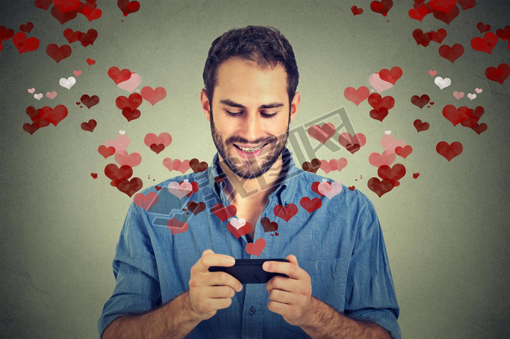 man sending love s message on mobile phone with hearts flying away