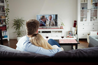 couple enjoying themselves and watching tv on the sofa