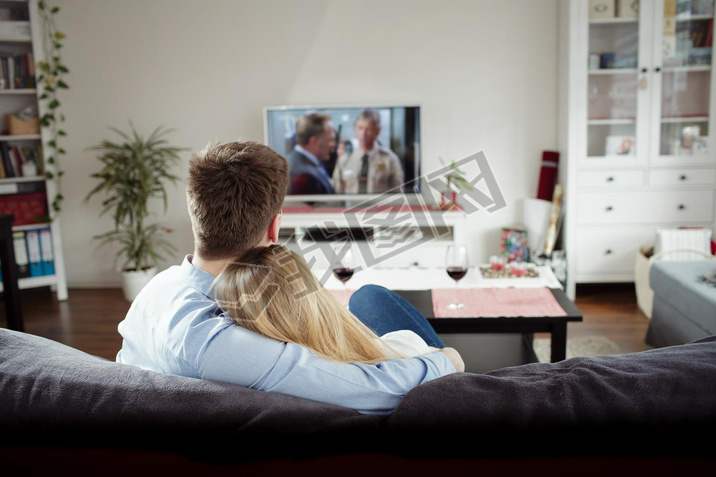 couple enjoying themselves and watching tv on the sofa