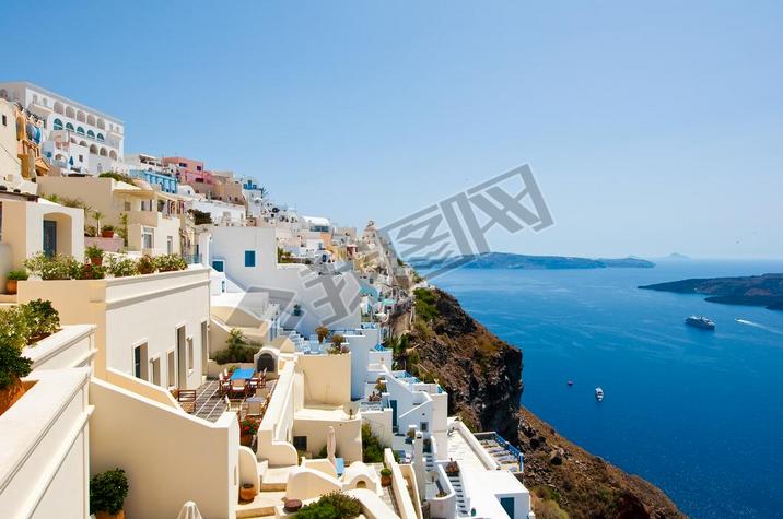 Panorama of Fira with whitewashed buildings carved into the rock on the edge of the caldera cliff on