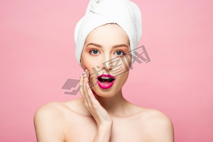 surprised and naked woman in white towel isolated on pink 