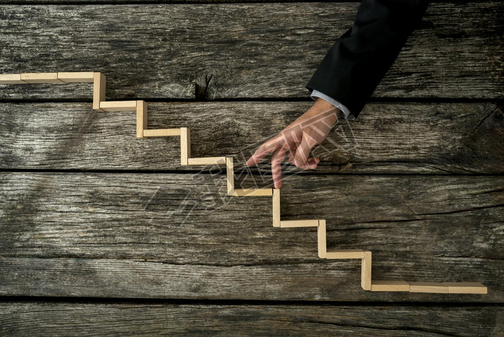 Businesan or student walking his fingers up wooden steps