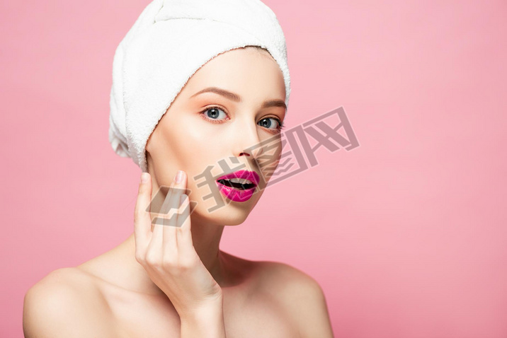 surprised naked woman in white towel isolated on pink 