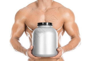 Bodybuilding and Sports theme: handsome strong bodybuilder holding a plastic jar with a dry protein