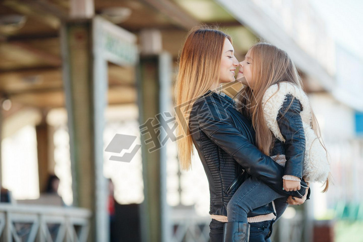 Mother holding daughter in her arms,standing in the fresh air