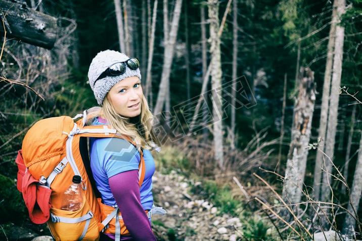 Woman hiking in winter cold dark winter forest