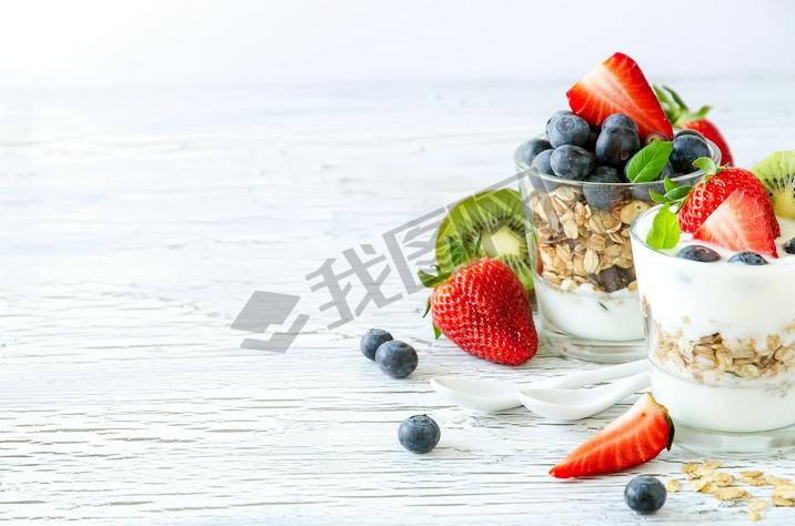 Healthy breakfast with muesli in glass, fresh berries and yogurt