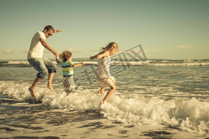 far, dotter och son spelar p? stranden p? dagarna