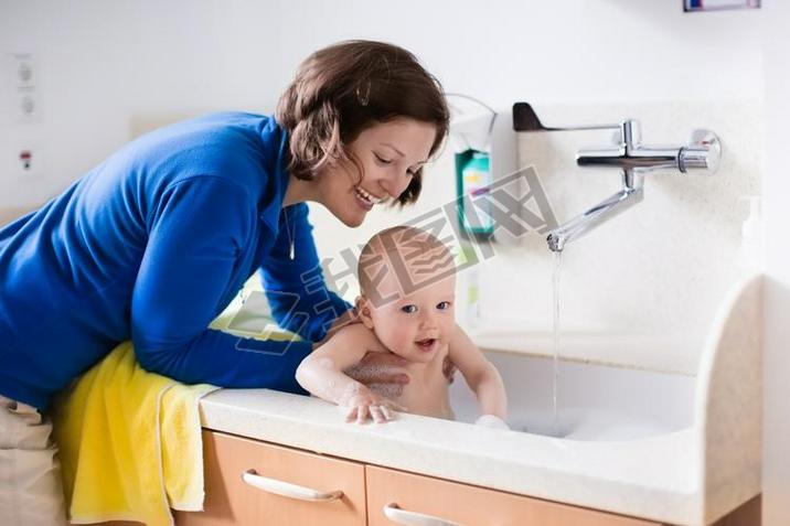 Mother bathing baby in hospital room