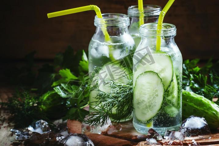 Refreshing cold drink of cucumber and herbs in glass bottles