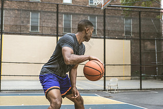 Afro-american basketball player training on a court in New York - Sportive man playing basket outdoo